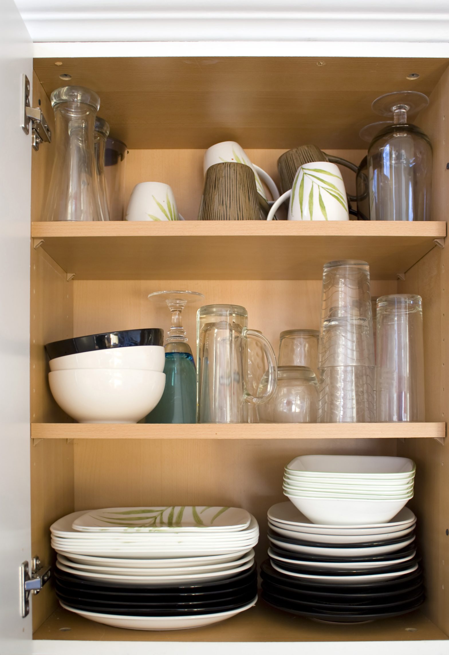 Cabinet filled with various dishware to pack for a move